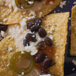 what's black and white and red all over? My white cheese nachos with black beans and salsa rojo. Recipe and photo by Jackie Alpers