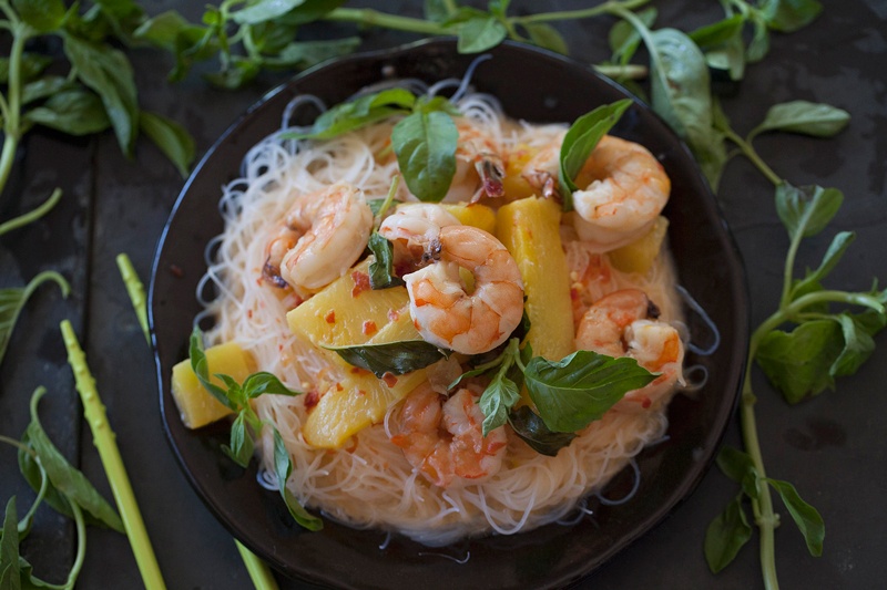 pineapple shrimp curry surrounded by Thai basil