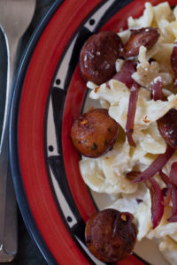 Red wine sausages and creamy white noodles close-up: photo and recipe by Jackie Alpers