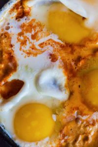close up of egg, cream and sauce in a pan of Shakshuka which is somewhat similar to Sonoran Eggs Diablo.