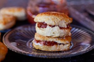 two buttermilk biscuits served with butter and jam