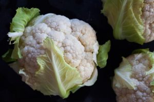 raw baby cauliflower with leaves attached