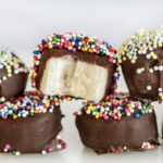 chocolate covered banana bites with a bite missing and colorful nonpareils