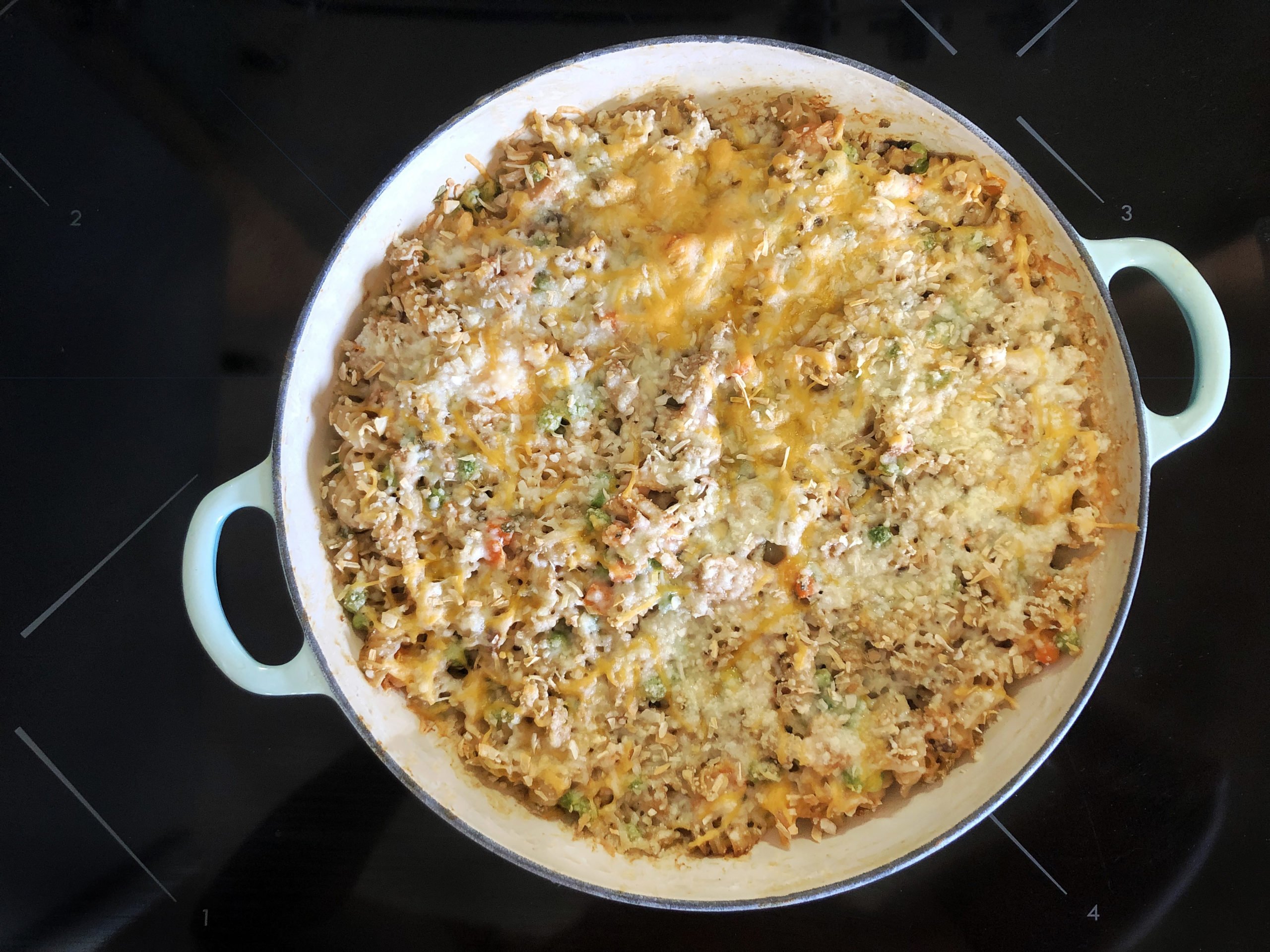 Tuna noodle casserole in Le Creuset dish on stovetop.