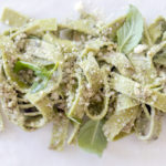 Fat, green spinach linguine with Parmesan, walnut pesto and basil leaves.