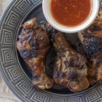Grilled Sonoran style chicken legs on a Frank lloyd Wright plate with salsa