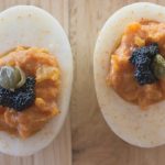 chipotle deviled eggs topped with caviar and capers and sprinkled with chile