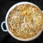 Tuna noodle casserole in a La Creuset braiser topped with cheese