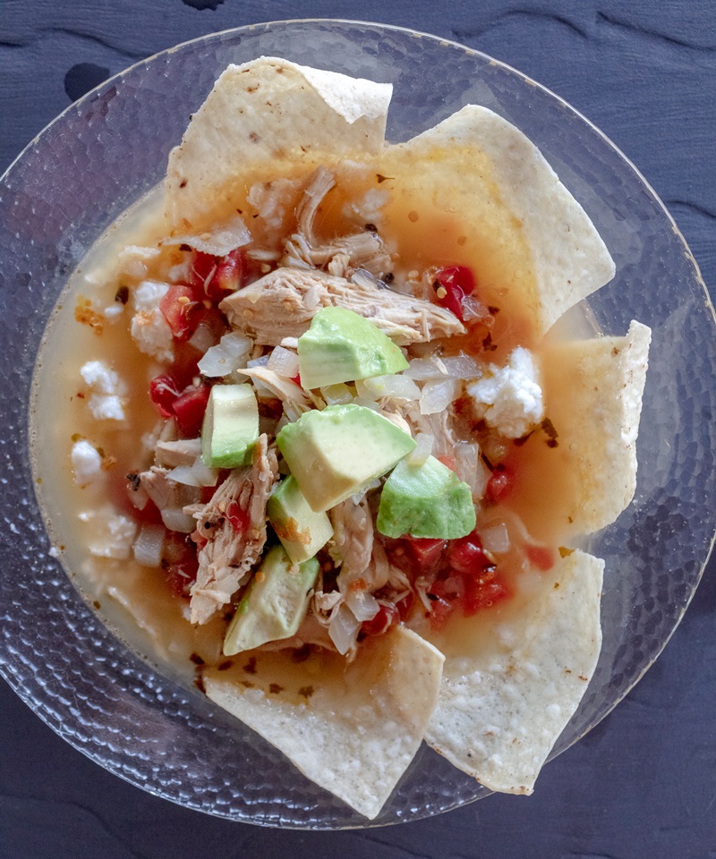 chicken tortilla soup served with avocado and tortilla chips