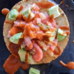 shrimp citrus ceviche served on baked tortillas with fresh avocado and hot sauce.