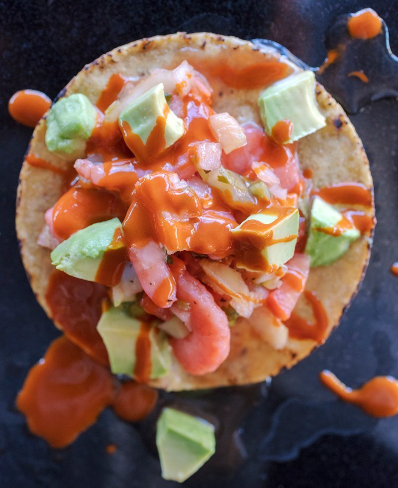 shrimp citrus ceviche served on baked tortillas with fresh avocado and hot sauce.