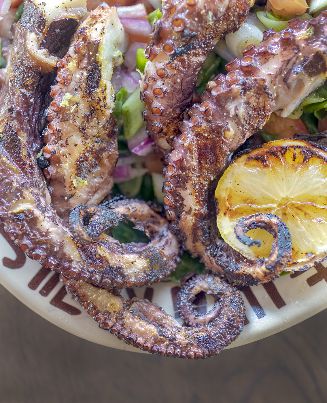 Mediterranean Diet Grilled Octopus with scallion, tomatoes and romaine on a Westward Ho platter.