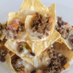 stack of bison nachos dripping with cheese. food photography and recipe by Jackie Alpers.