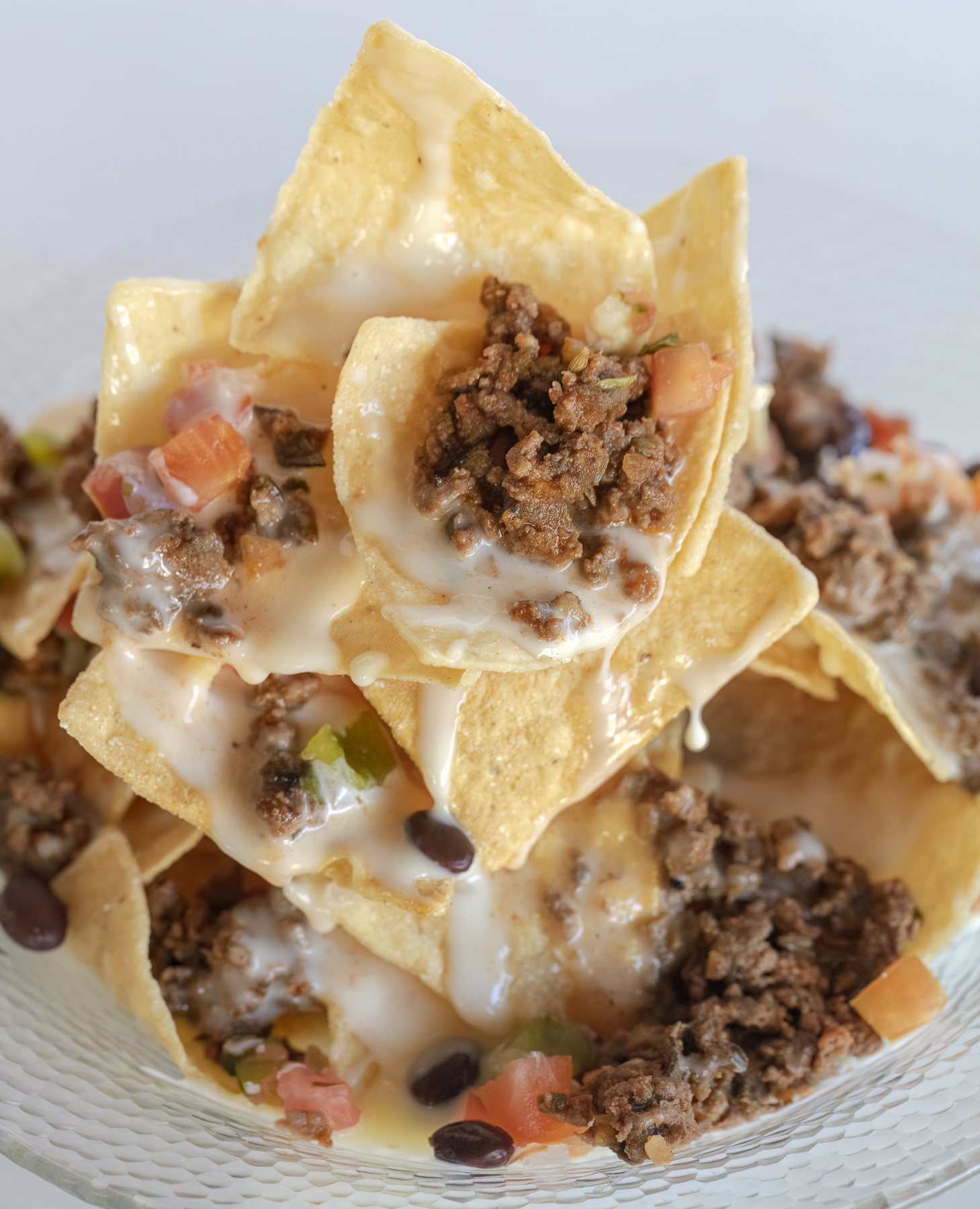 stack of bison nachos dripping with cheese. food photography and recipe by Jackie Alpers.
