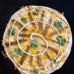 recipe for Arizona style Southwestern flour tortilla cheese crisp with Mexican blend cheese roasted green chile strip, cilantro leaves and ranch spiral.