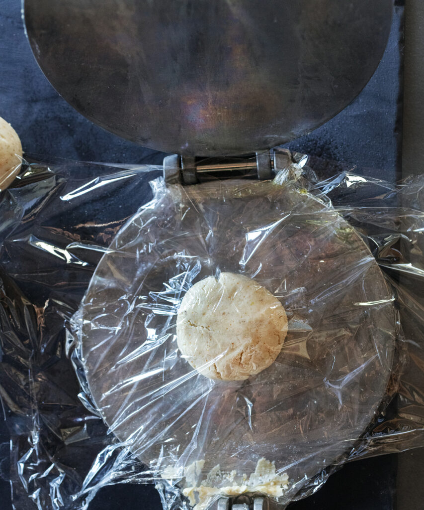 How to make blue corn tortillas step 5 flatten: recipe and food photography by Sonoran cookbook author Jackie Alpers.