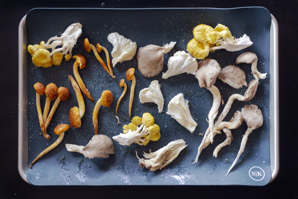 roasting exotic mushrooms on a sheet pan lined with a Silicone kitchen baking mat. Recipe instructions and photography by Jackie Alpers for The Silicone Kitchen.