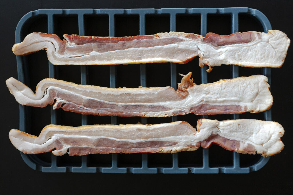 thick cut raw bacon on a silicone ktchen roasting rack. Recipe instructions and photography by Jackie Alpers for The Silicone Kitchen.