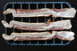 thick cut raw bacon on a silicone ktchen roasting rack. Recipe instructions and photography by Jackie Alpers for The Silicone Kitchen.