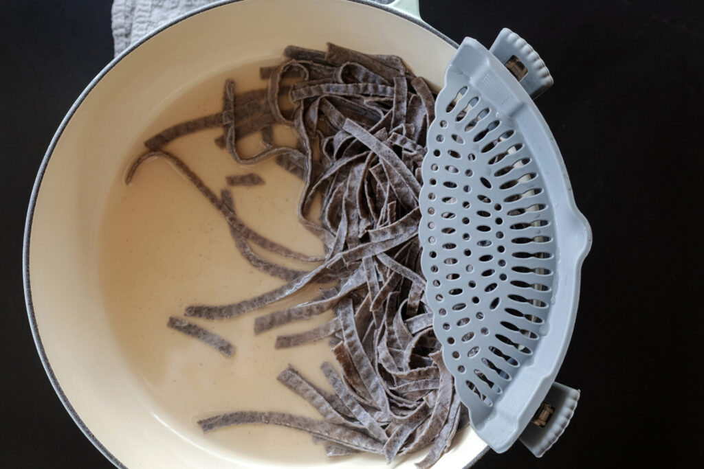 draining pasta with a silicone kitchen pot strainer. Recipe prep photography by Jackie Alpers for The Silicone Kitchen