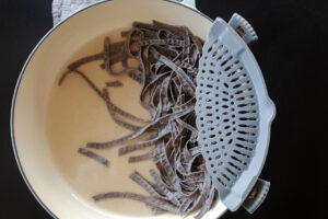 draining pasta with a silicone kitchen pot strainer. Recipe prep photography by Jackie Alpers for The Silicone Kitchen