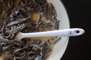 stirring pasta water and eggs to make carbonara with a Silicone Kitchen spatula. Recipe step-by-step photography by Jackie Alpers for The Silicone Kitchen.