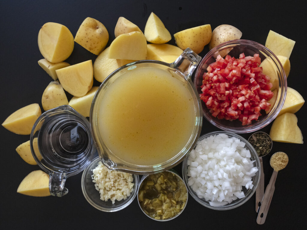Sonoran style Caldo de queso soup with large chunks of potatoes, melty cheese, mexican oregano and chiltepin. Food photography and recipe by Jackie Alpers author of the Taste of Tucson cookbook.