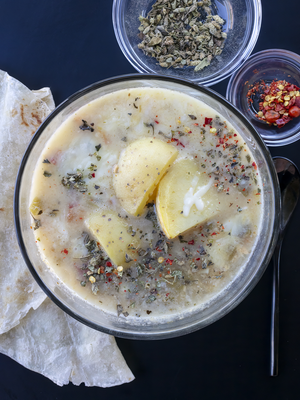 Caldo de queso soup with large chunks of potatoes, melty cheese, mexican oregano and chiltepin. Food photography and recipe by Jackie Alpers for Serious Eats.