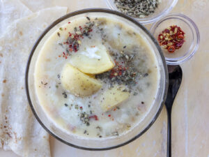 Caldo de queso soup with large chunks of potatoes, melty cheese, mexican oregano and chiltepin. Food photography and recipe by Jackie Alpers for Serious Eats.