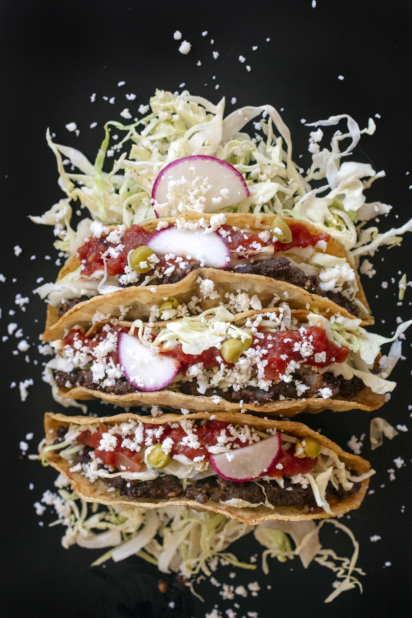 Ground beef patties folded into handmade tortillas and then friend before loading with the traditional toppings. One of our iconic Tucson dishes. Food photography and article by Jackie Alpers.