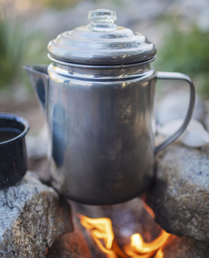 Pot of cowboy coffee brewing over an open campfire with rocks as anchors. Photography and recipe from the Arizona-Mexico borderlands by Sonoran cookbook author Jackie Alpers Jackie Alpers