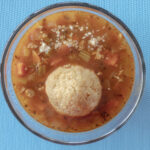 Huge matzo ball floating in Sonoran-style albondigas Matzo ball soup.